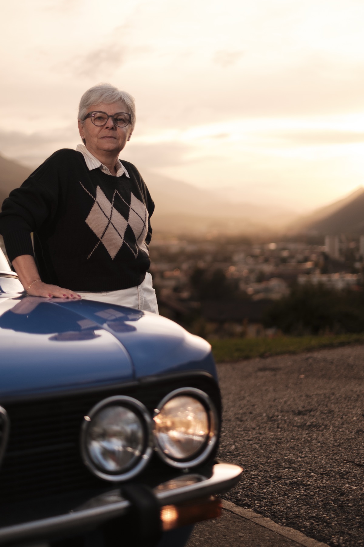 Autofotografie Alfa Romeo Giulia, Fahrerin bei Sonnenuntergang über Chur, Graubünden