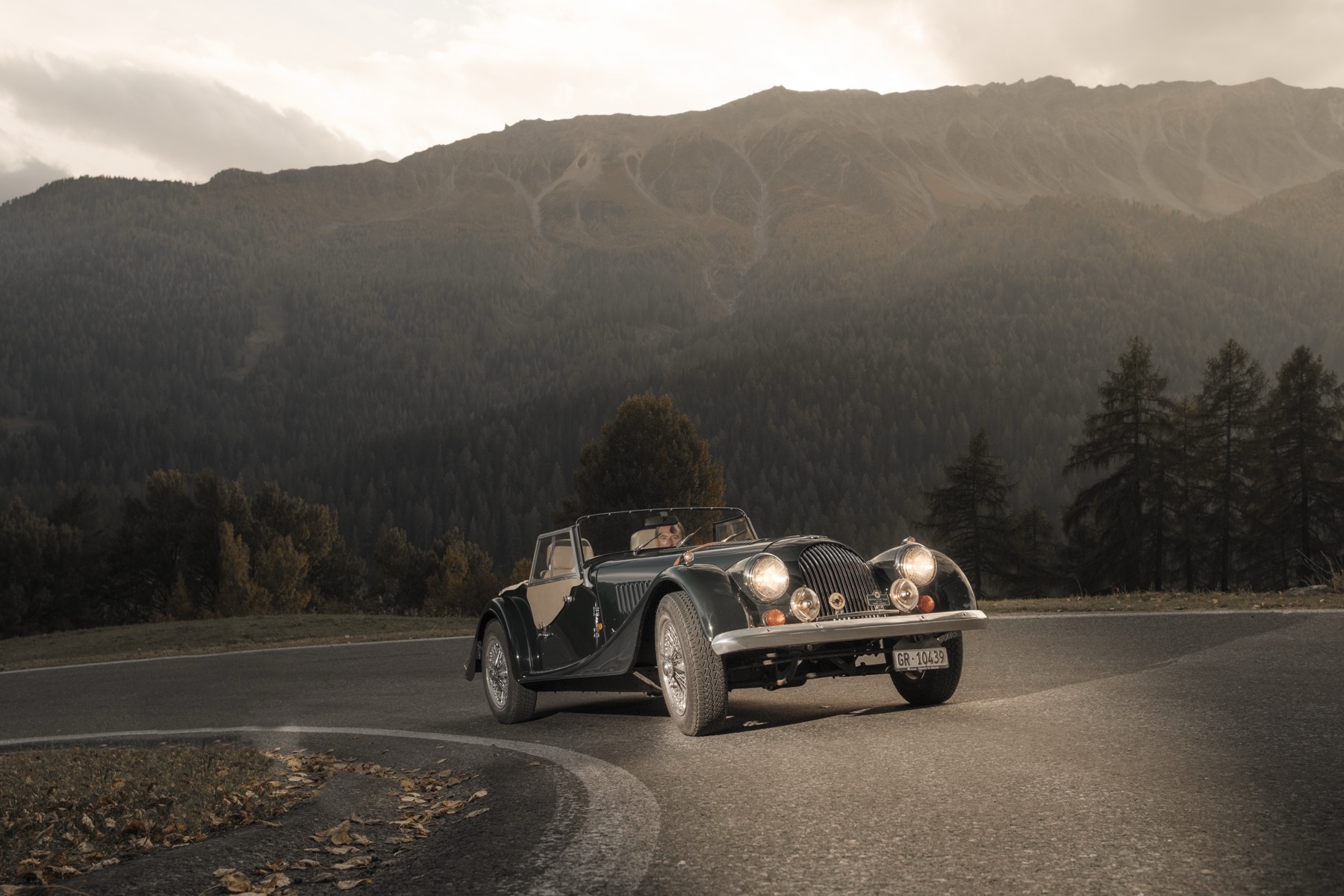 Autofotografie Morgan Roadster unter dramatischem Gewitterhimmel, Graubünden