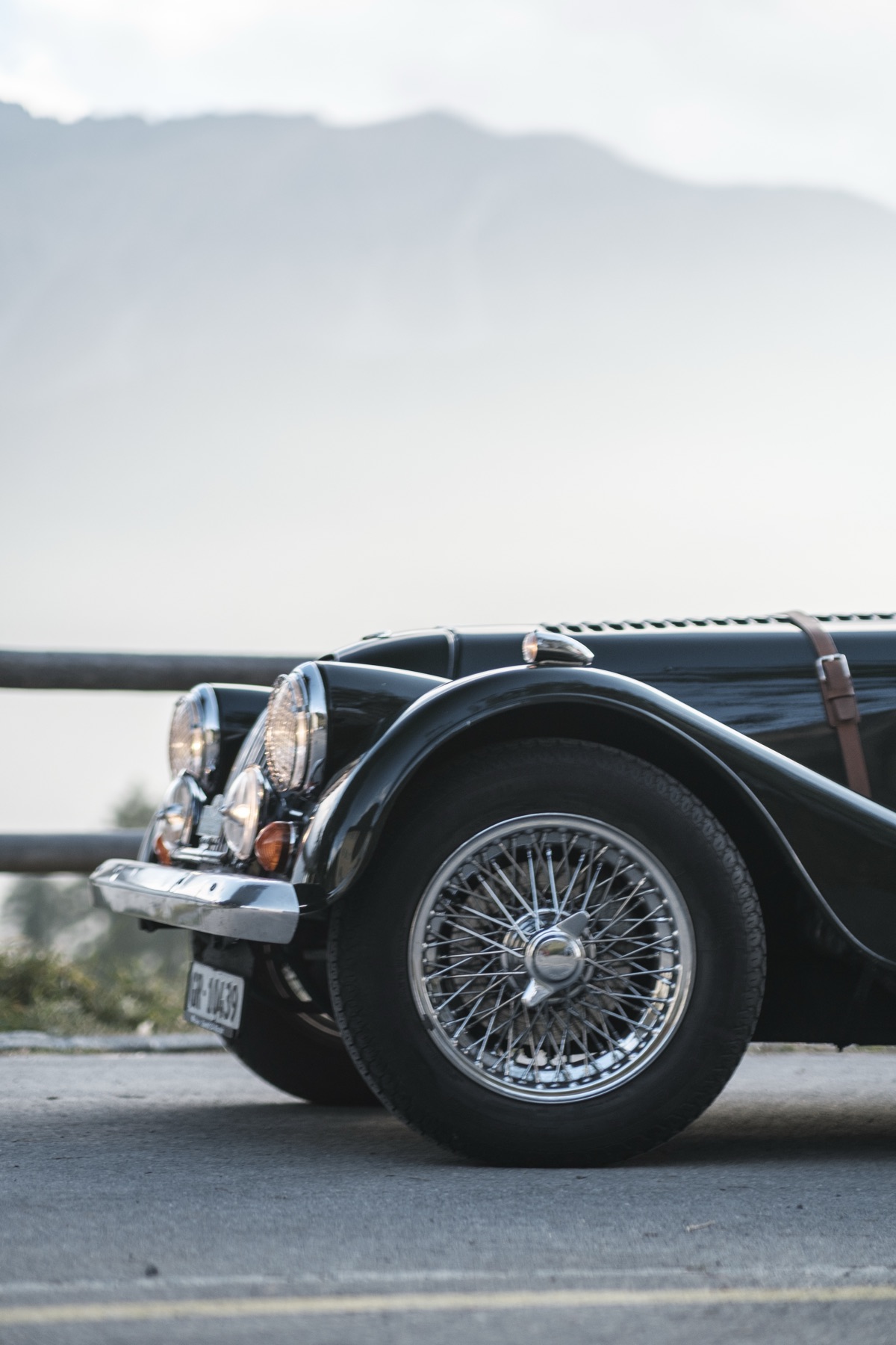 Autofotografie Morgan Roadster in einer Kurve im Nebel, Graubünden