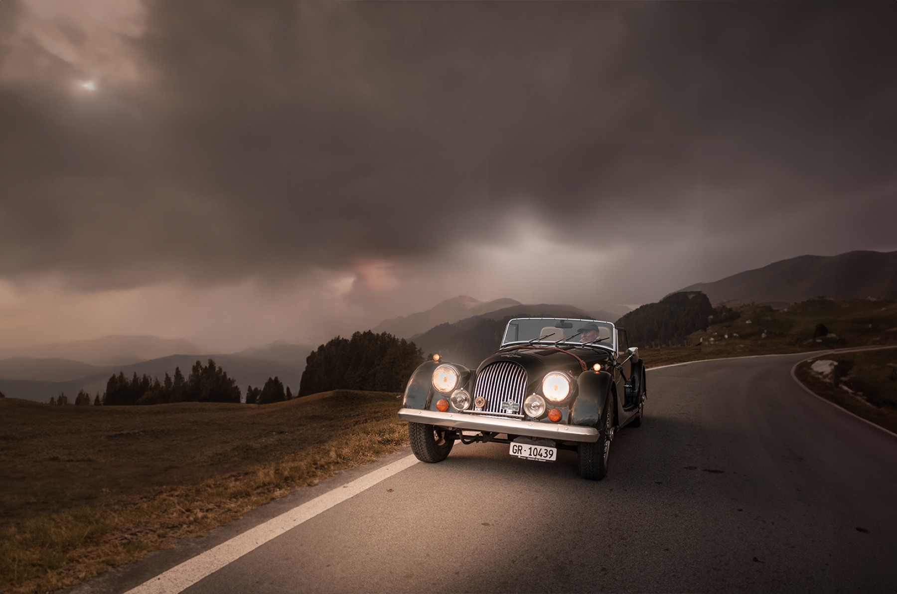 KI-generiertes Bild eines Morgan Roadster unter dramatischem Himmel, Beispiel aus dem Shooting