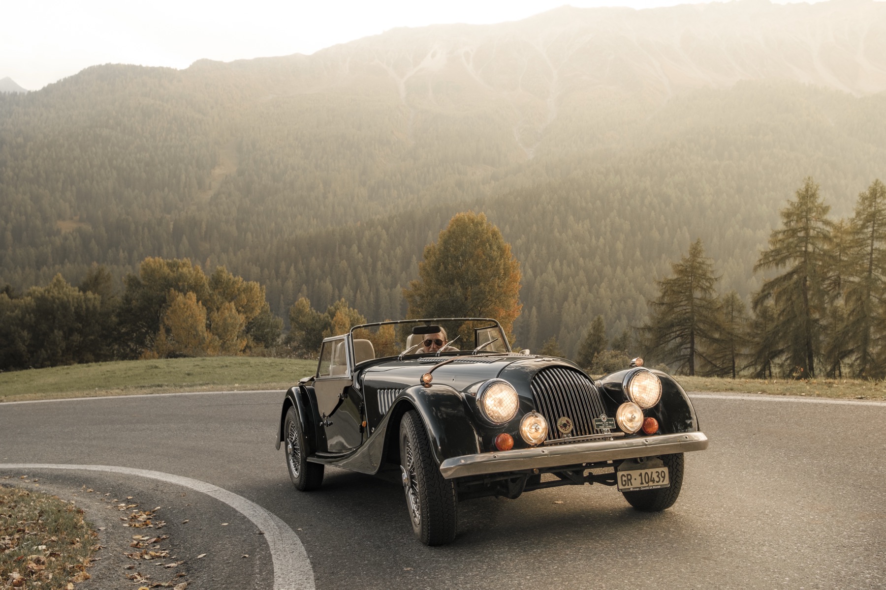 Autofotografie Morgan Roadster auf einer Waldstrasse, Graubünden